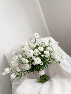 a bouquet of white flowers sitting on top of a bed