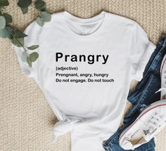 a white t - shirt with the words prangry on it next to some jeans