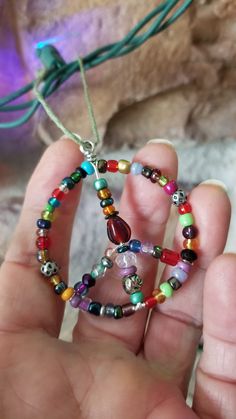 a person holding a beaded necklace in their hand