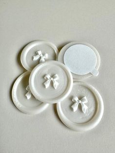 four white plates with bows on them and a speech bubble in the middle one is empty