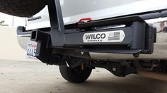 the back end of a white truck parked in a parking lot