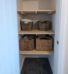 an empty closet with baskets on the shelves