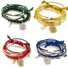 four different colored bracelets with charms on them