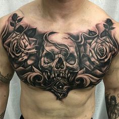 a man's chest with tattoos and roses on it