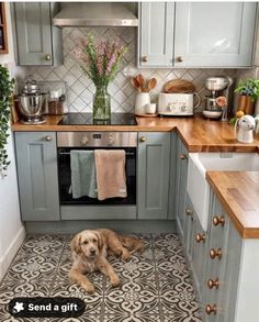 a dog is laying on the kitchen floor in front of an oven and counter top