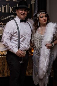 a man and woman standing next to each other in front of a sign that says happy birthday