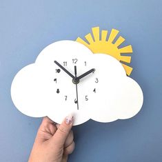 a hand holding a paper clock with the shape of a cloud