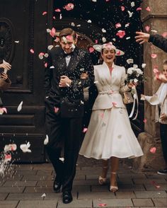 a newly married couple walking down the street with confetti falling all around them