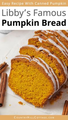 a loaf of pumpkin bread with white icing on top and cinnamon sticks next to it