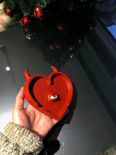 a hand holding a red heart shaped object