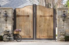 a bicycle is parked in front of two wooden doors with iron bars on the sides