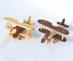 two wooden toy airplanes sitting next to each other