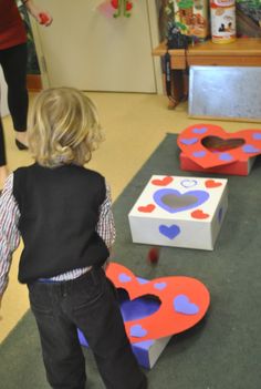 a little boy playing with some toys in a play room at a school or community center