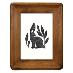 a black and white drawing of a rabbit with leaves on it's head in a wooden frame