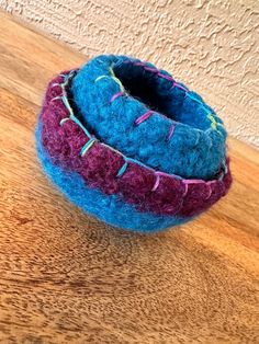 a blue and purple ball sitting on top of a wooden table