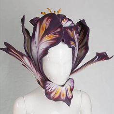 a white mannequin with purple flowers on it's head