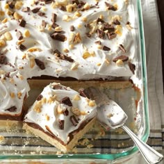 there is a cake with white frosting and nuts on the top, next to a fork