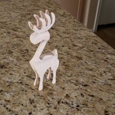 a white deer figurine sitting on top of a counter