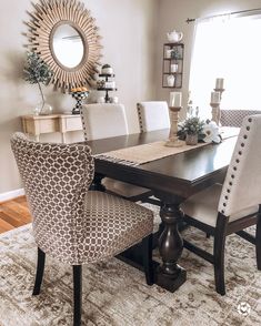 a dining room table with chairs and a mirror on the wall