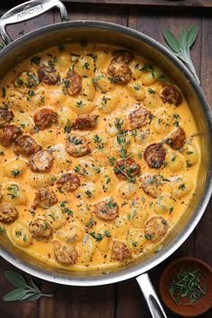 a pot filled with pasta and meatballs on top of a wooden table