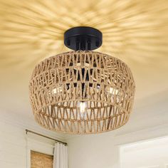 a light that is hanging from the ceiling in a room with white walls and wood flooring