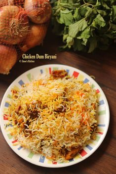 chicken dum biriyani served on a plate with vegetables in the background