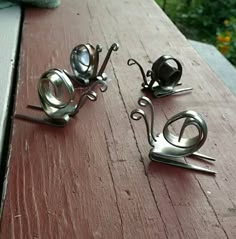 three metal objects sitting on top of a wooden table