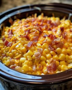 a crock pot filled with corn and bacon