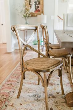 two wooden chairs sitting on top of a rug