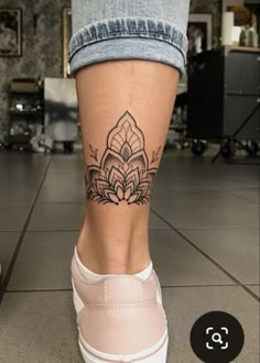 a woman's leg with a tattoo on it, and the bottom half of her legs