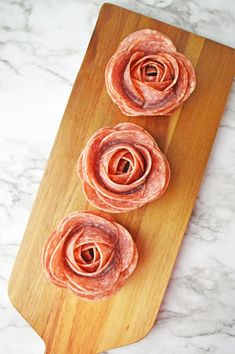 three pieces of food on a cutting board with some sort of spirals in the middle