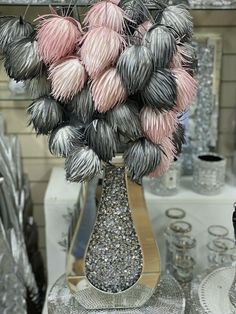 a vase filled with silver and pink flowers on top of a table next to other items