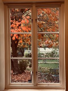 an open window with autumn leaves outside