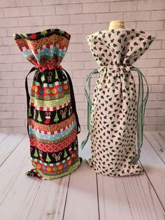 two bags sitting next to each other on top of a wooden floor with brick wall behind them