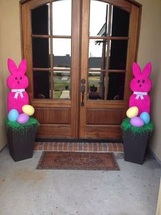 two plastic easter bunnies sitting in front of a door