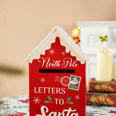 a red house shaped mailbox with the words north pole letters to santa written on it