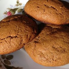 three cookies are on a plate with flowers