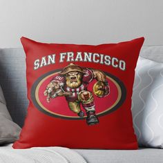 a san francisco football team throw pillow on a couch with the name and mascot in red