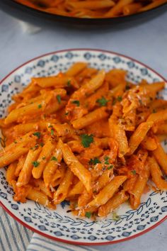 a plate full of pasta with sauce and parsley