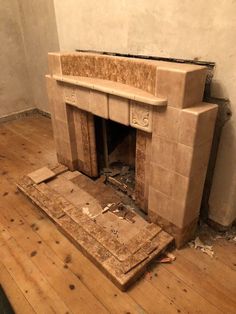 an old fireplace is being remodeled in a room with wood flooring and unfinished walls