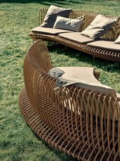 two wicker couches sitting in the grass