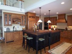 a large kitchen with wooden cabinets and an island in the middle, along with bar stools