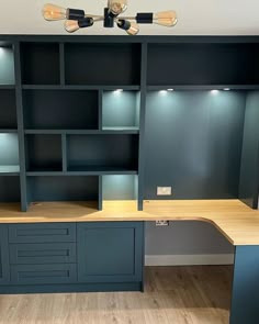 an empty office with shelves and desks in the middle of it, surrounded by wood flooring