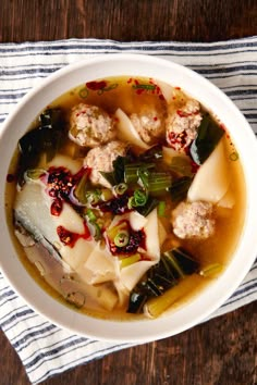 a white bowl filled with soup on top of a wooden table