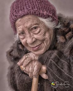 an old woman holding a stick and smiling