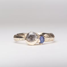 two gold rings with blue sapphire stones on each one and the other handmade ring