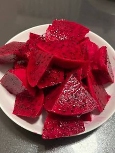 a white plate topped with sliced up red fruit