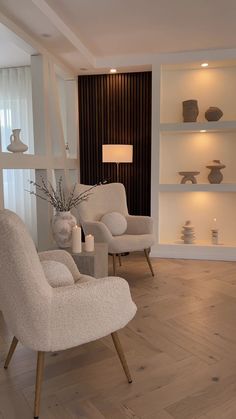 two white chairs sitting next to each other on top of a hard wood floored floor