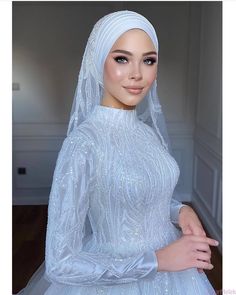 a woman in a white dress and veil posing for a photo with her hands on her hips