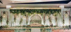 a decorated stage with chairs and greenery